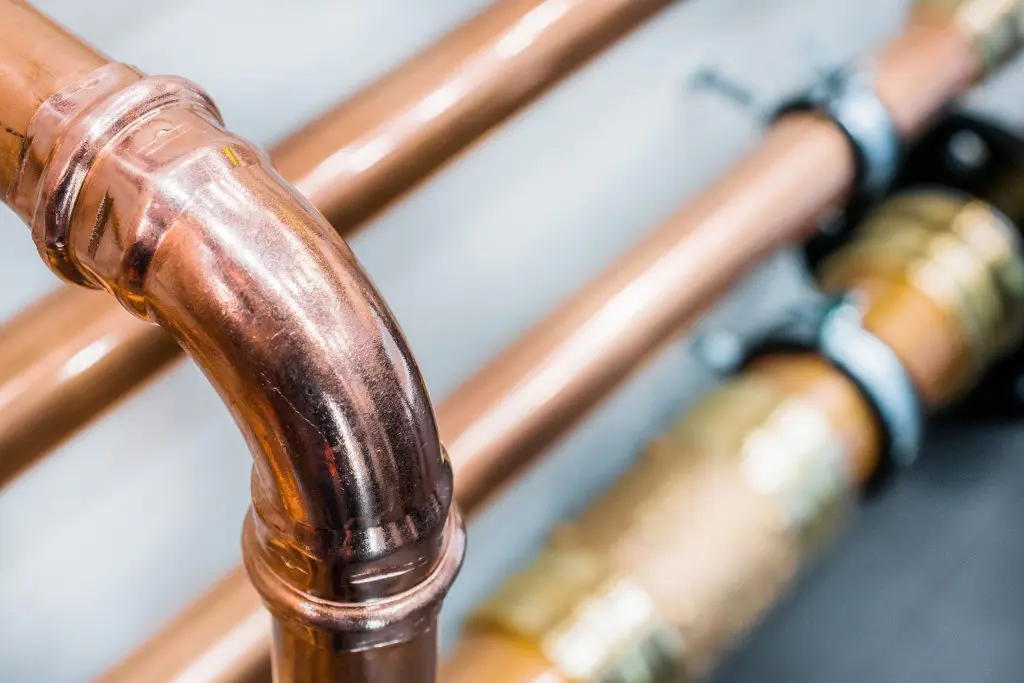 Brilliant new copper pipes. Connection of copper pipes blooming fitting.